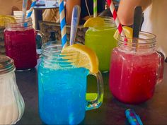 there are many different colored drinks in mason jars with straws on the top and bottom