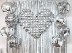 an art piece with many shiny balls hanging from it's sides and on the wall