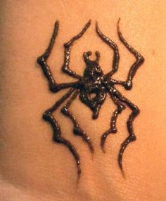 a spider tattoo on the back of a woman's arm