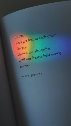 an open book with a rainbow colored light coming from the pages and writing on it