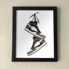 a black and white photo with a pair of shoes hanging from it's side