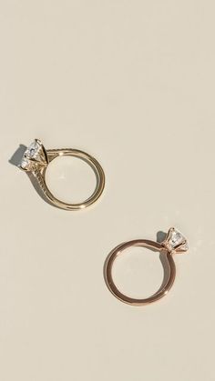 two pairs of gold rings with diamonds on each one, sitting next to each other