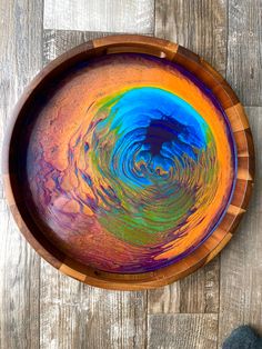 a wooden bowl filled with colorful liquid on top of a table