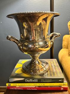 a silver vase sitting on top of a stack of books