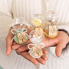 a person holding three small ornaments in their hands