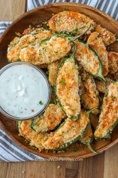 baked zucchini fries with ranch dressing in a wooden bowl on a striped towel