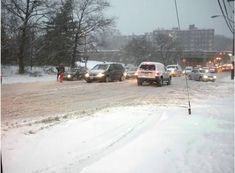 cars driving down a snow covered road in the winter