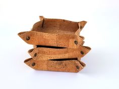 four pieces of cork stacked on top of each other in a holder with holes at the bottom