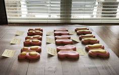 some cookies that are on a table with sticky notes in front of the doughnuts