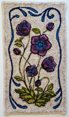 an embroidered square with purple flowers on it