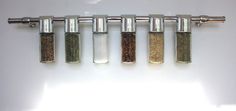 five spice bottles are lined up on the wall to display their different types of spices