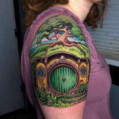 a woman with a tattoo on her arm has a green door and tree in it