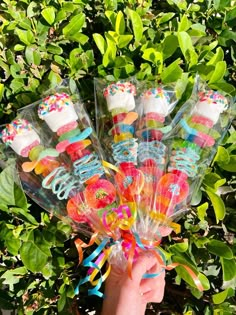 a person holding up a bunch of birthday cake lollipops in their hands