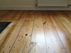 an empty room with wooden floors and white radiator