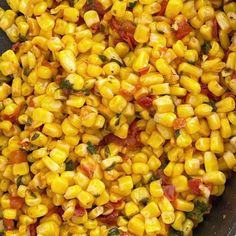 corn with tomatoes and basil in a skillet ready to be cooked on the stove