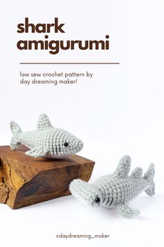 two small crocheted fish sitting on top of a wooden block with the caption shark amigurmi low saw crochet pattern by day dreaming maker