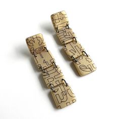 two wooden earrings with numbers on them sitting next to each other in front of a white background