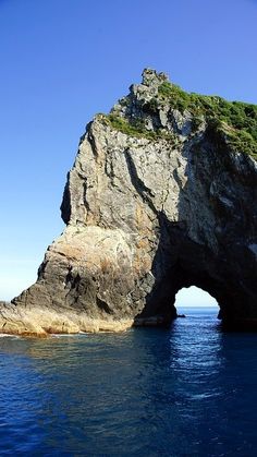 an arch in the water near a rock formation