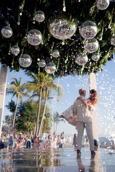 a man and woman standing under a tree filled with bubbles