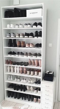 a white shoe rack filled with lots of shoes next to a door in a room