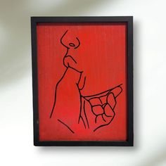 a red painting with a black frame hanging on the wall