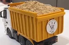 a toy truck with a large amount of sand in it's back end on a table