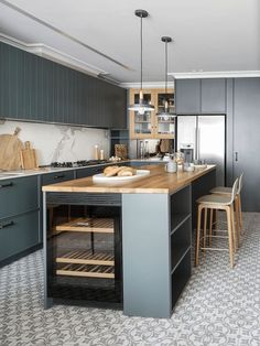 a kitchen with gray cabinets and wooden counter tops