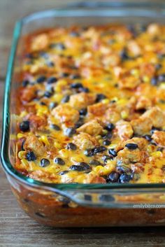 a casserole dish with chicken and black beans in it on a wooden table