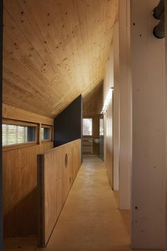 an empty hallway with wooden walls and ceilinging in a house that is made out of wood