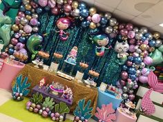 there are many balloons and decorations on the wall in this room, including mermaid theme