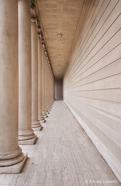 an empty hallway between two rows of columns