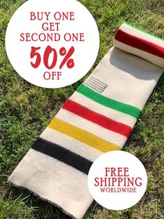 a striped scarf is on the grass with a sale tag in front of it that says, buy one get second one 50 % off