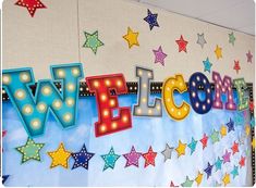 the word welcome written in neon letters on a bulletin board with stars and confetti