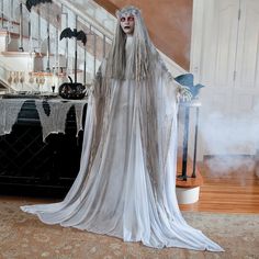 a woman dressed up as a ghost standing in front of some stairs