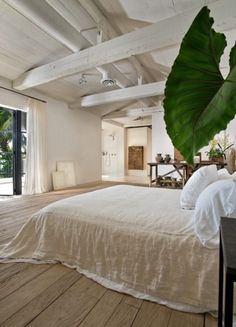 an instagram photo of a bed with white sheets and pillows in a loft bedroom