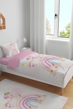 a child's bedroom with pink and white bedding, rugs and curtains