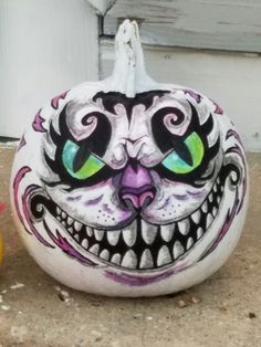 a painted pumpkin sitting on top of a sidewalk