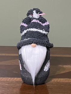 an old fashioned knitted gnome is sitting on a table