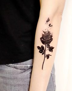 a black rose tattoo on the left arm