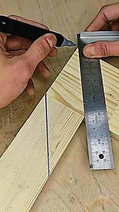 two hands are holding a ruler and measuring wood