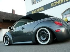 the back end of a gray car parked in front of a building