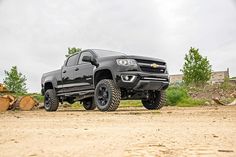 a black truck parked on top of a dirt road