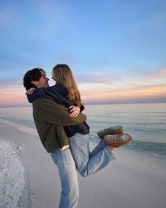 a man and woman hugging on the beach