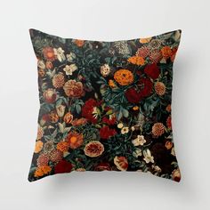 a pillow with an image of flowers and leaves in red, orange, yellow and green