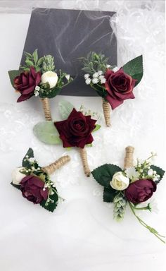 six boutonnieres with white and red flowers