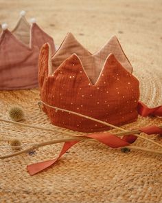 two crowns sitting on top of a straw floor