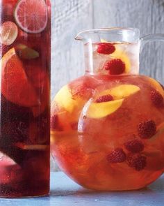 a pitcher and jug filled with liquid sitting next to each other on top of a table