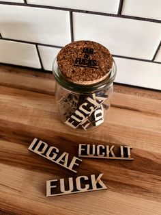 some type of sticker sitting on top of a wooden table next to a glass jar