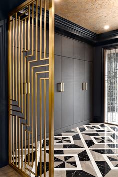 a black and white marble floor with gold accents in a room that has large windows