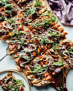 a pizza with many toppings sitting on top of a cutting board